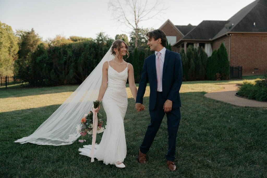 Wedding couple walking through a Nashville venue with photographer