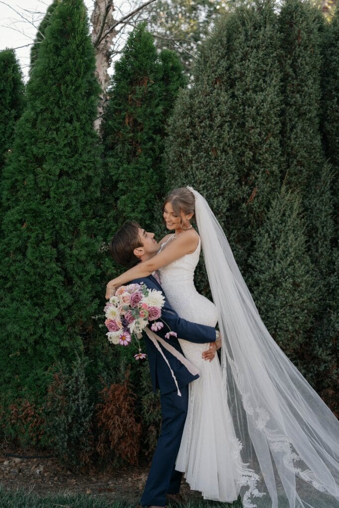 Groom picks up his bride during pictures in Nashville