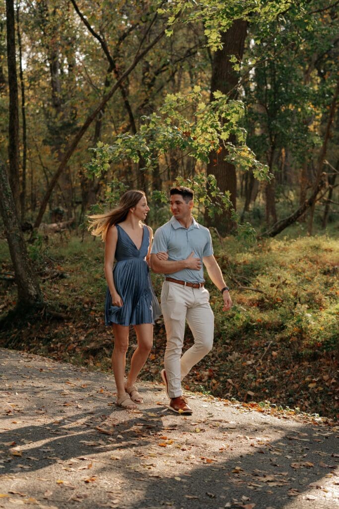 Newly engaged couple walking hand in hand at Percy Warner Park