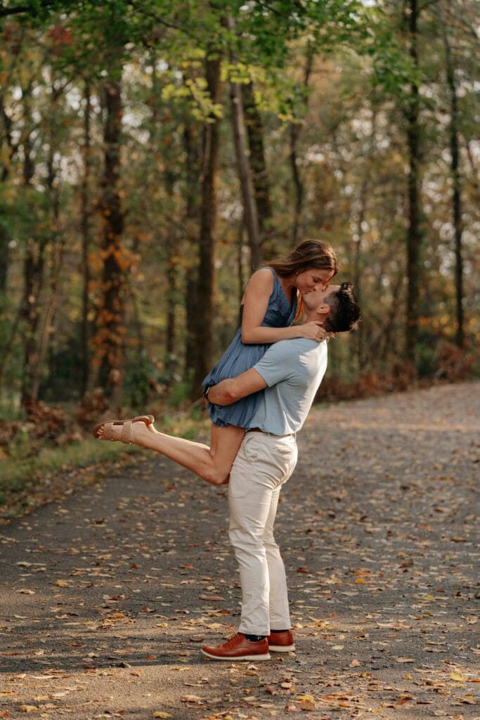 Newly engaged couple kisses during photos after surprise proposal at Percy Warner Park