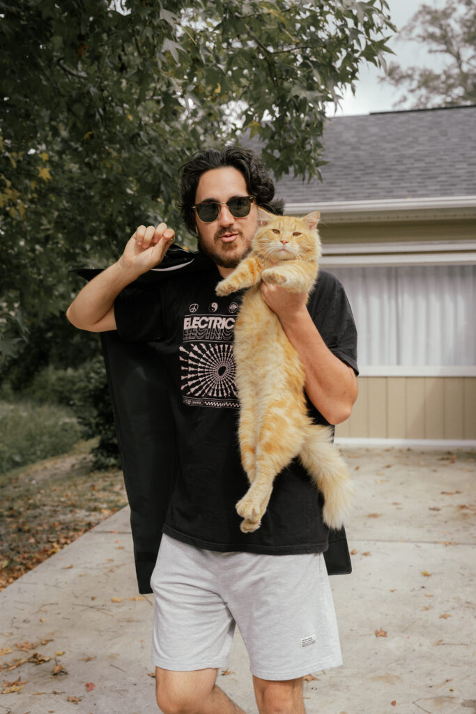 Groom in a black shirt holding his cat before his Nashville wedding.