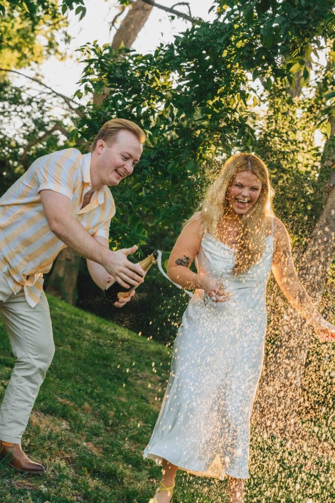 Couple popping champagne during their engagement session at Lovers Circle in Nashville TN 